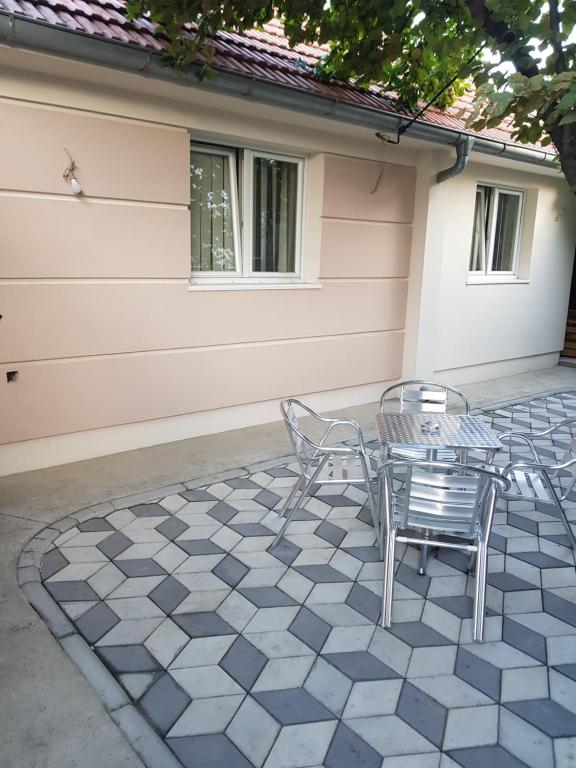 a patio with chairs and a table on a tile floor at Apartmani Strahinic in Leskovac