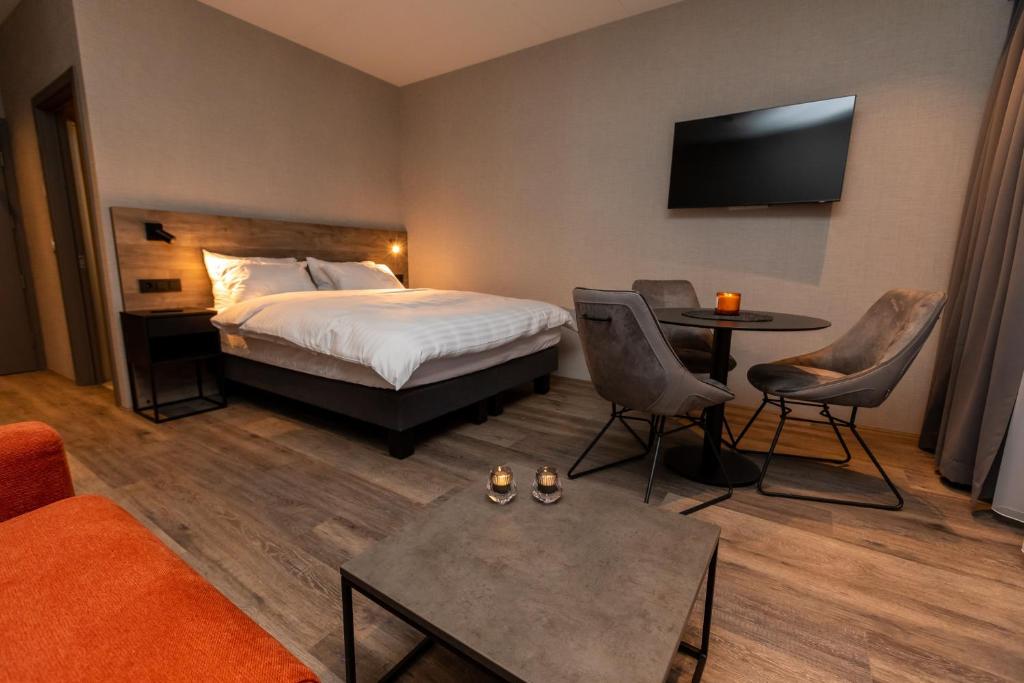 een hotelkamer met een bed en een tafel en stoelen bij Hotel Halond in Akureyri