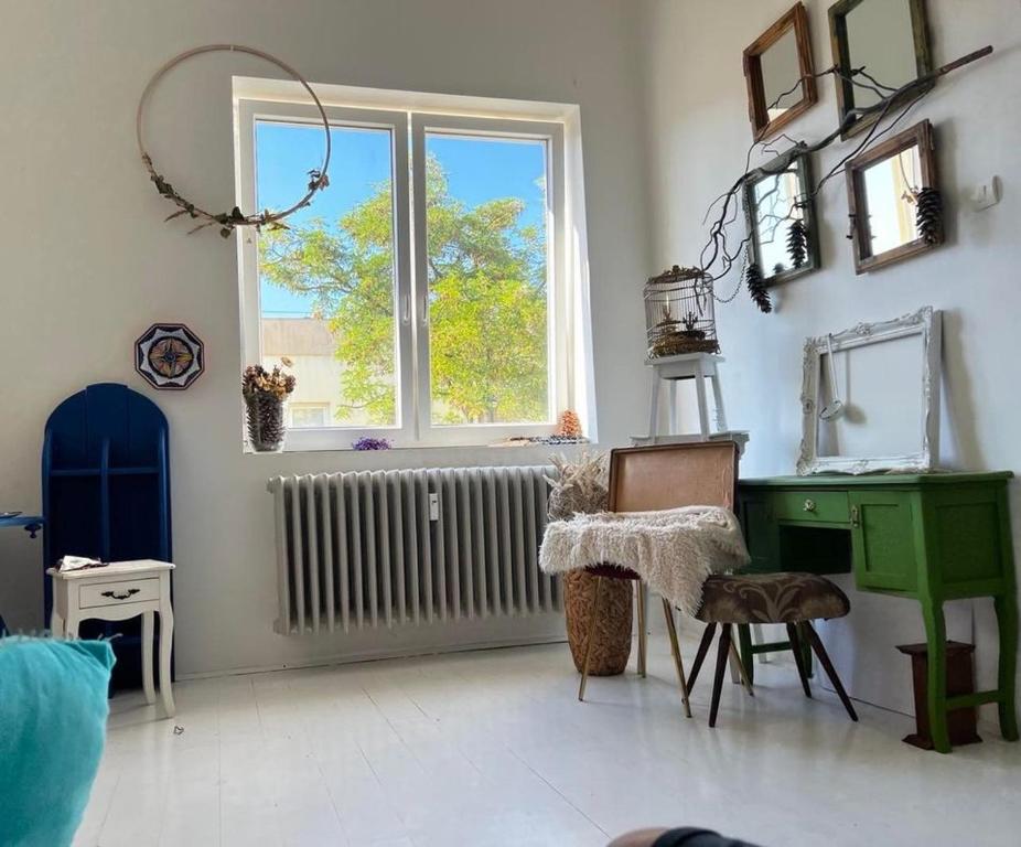 um quarto com uma secretária verde e uma janela em Stylish Delight in Downtown of Debrecen em Debrecen
