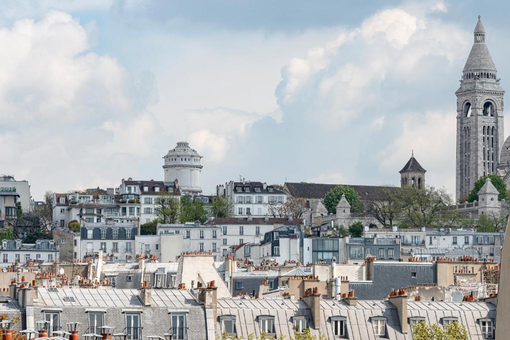 a city with white buildings and a clock tower at Grand Pigalle Hotel in Paris