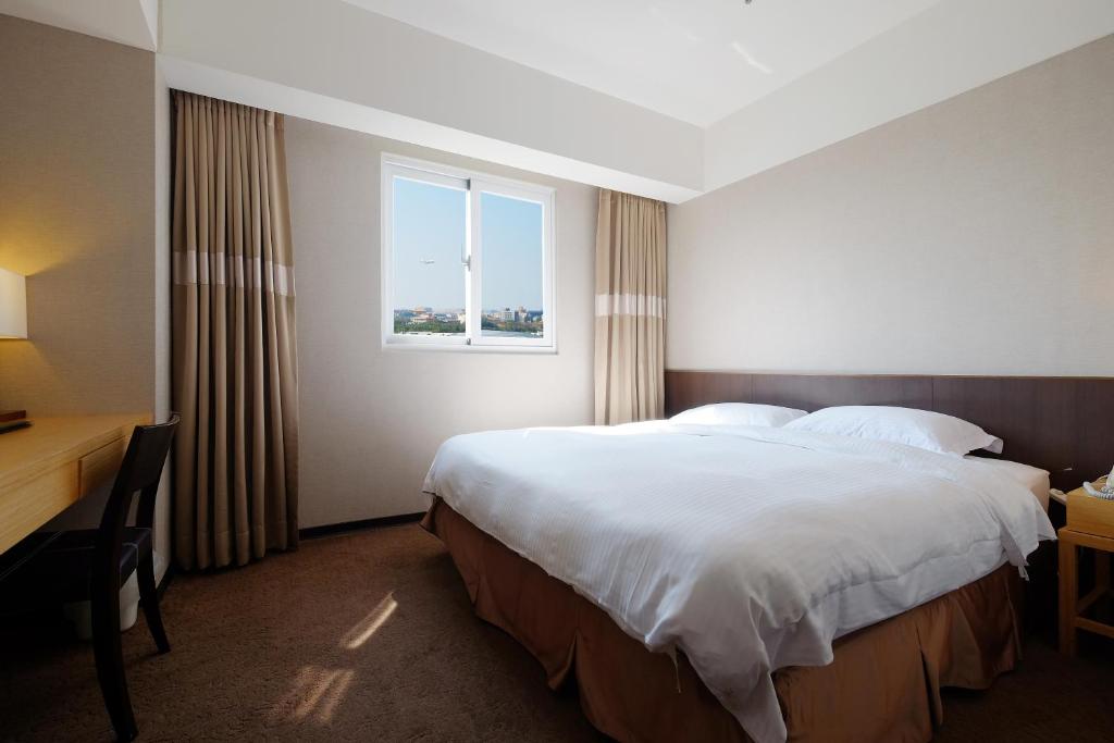 um quarto de hotel com uma cama grande e uma janela em City Suites - Taoyuan Gateway em Dayuan
