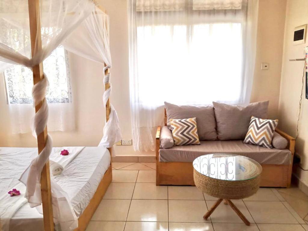ein Wohnzimmer mit einem Bett und einem Sofa in der Unterkunft Truthvacay in Mombasa