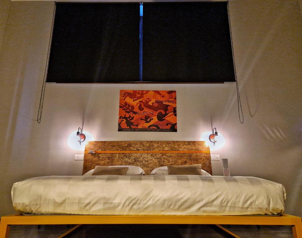 Un dormitorio con una cama con dos luces. en GARAGE47 Storica Officina Meccanica LOFT B&B iN PIENZA, en Pienza