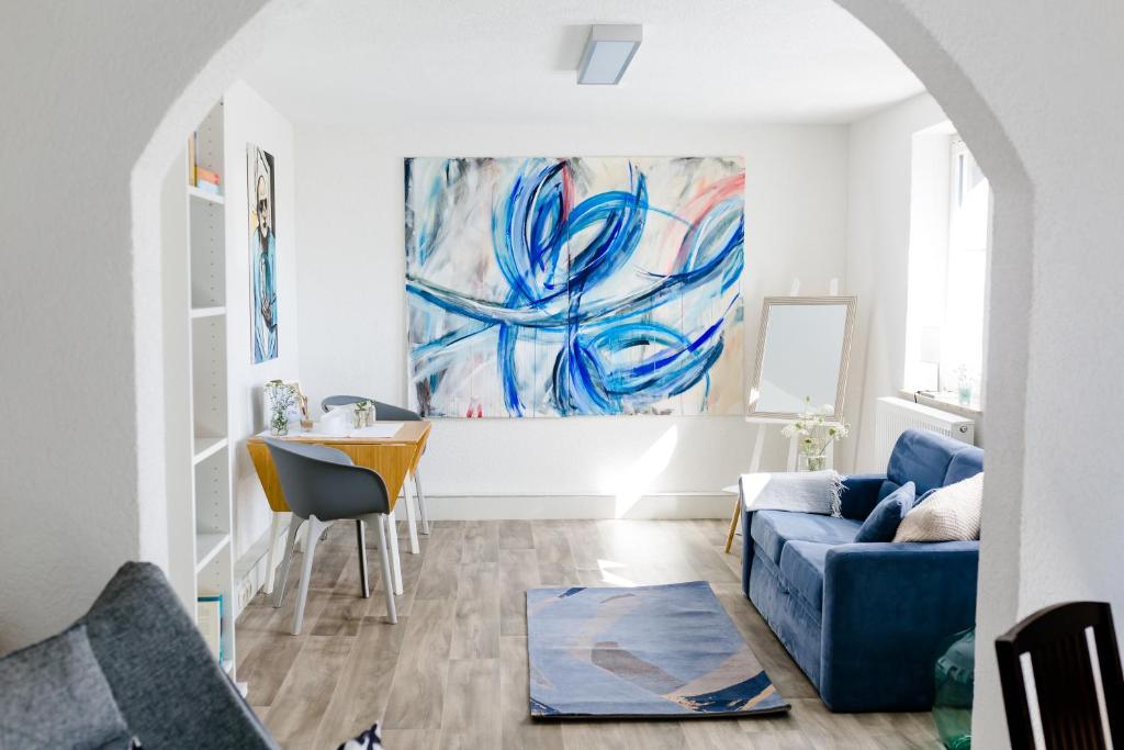 ein Wohnzimmer mit einem blauen Sofa und einem Tisch in der Unterkunft Kleines Kunsthaus. in Nordhausen