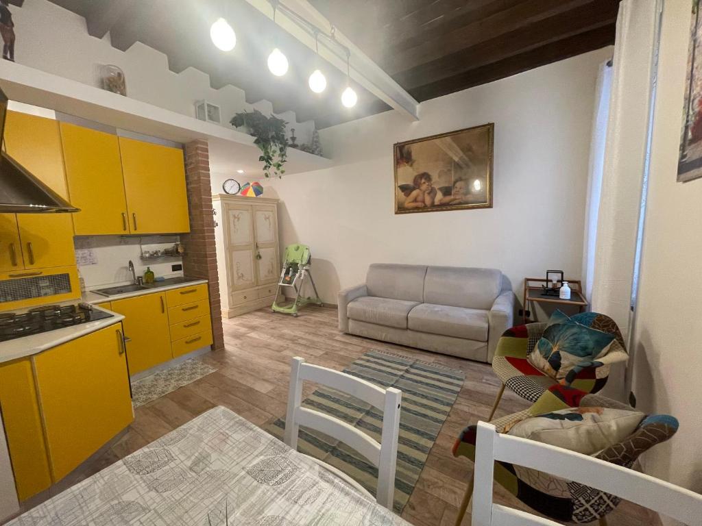 a kitchen and a living room with yellow cabinets at Casa Nicoli in Bergamo
