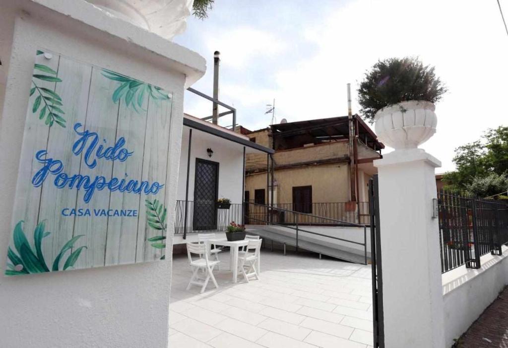 a white building with a sign on the side of it at Nido Pompeiano Casa Vacanze in Pompei