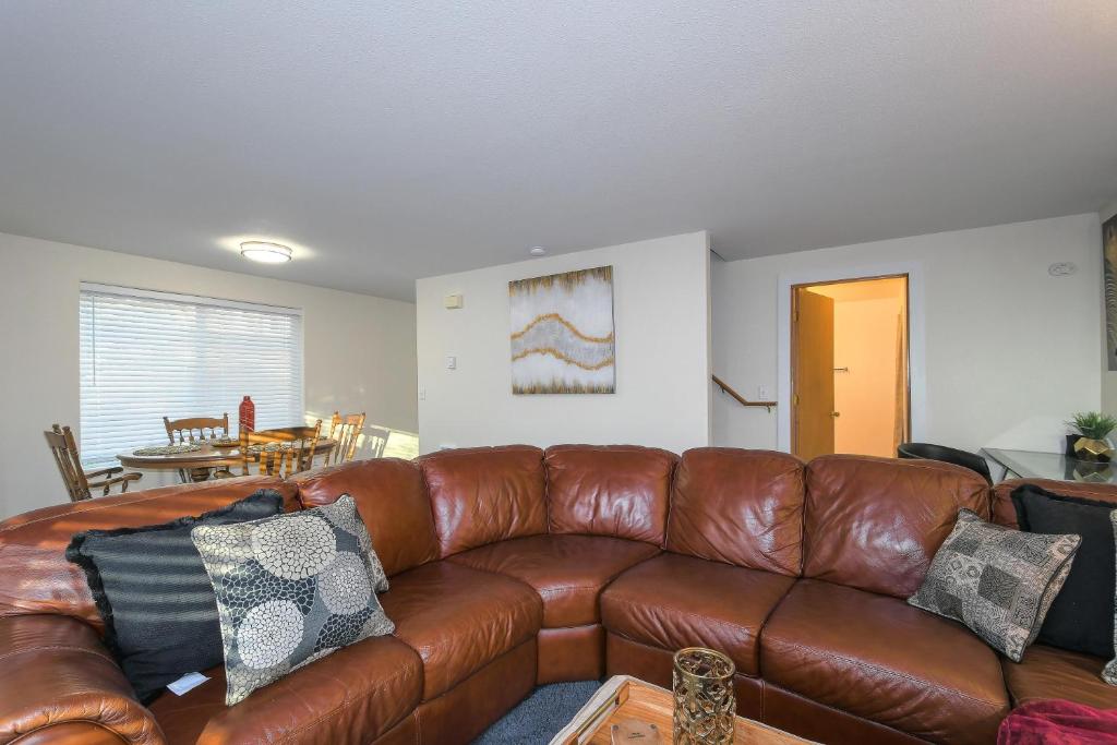 sala de estar con sofá de cuero marrón en Cozy Couve Apartment Close To Everything!, en Vancouver