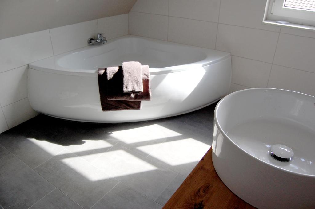 a white bathroom with a tub and a sink at Kleiner Onkel in Twist