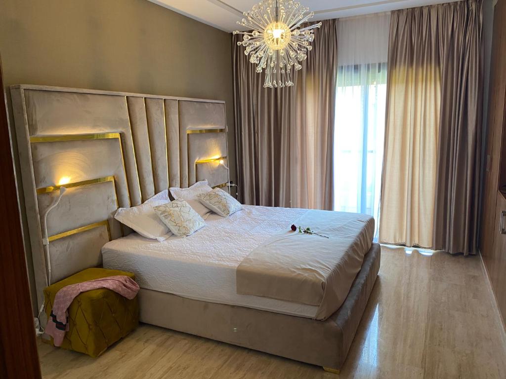 a bedroom with a large bed and a chandelier at Marchica Med atalayon in Nador