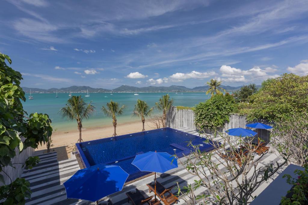 a swimming pool with umbrellas and a beach at X10 Seaview Suites at Panwa Beach in Panwa Beach