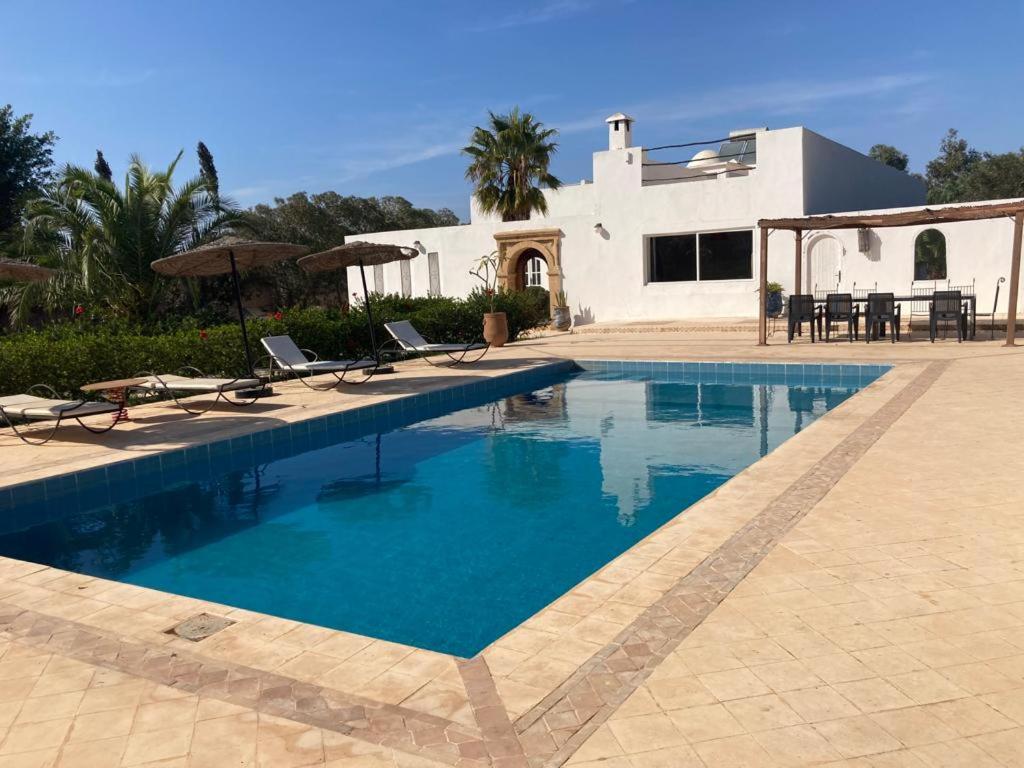 - une piscine avec des chaises et une maison dans l'établissement The House just 8 km from Essaouira and its beaches, à Ida Ougourd