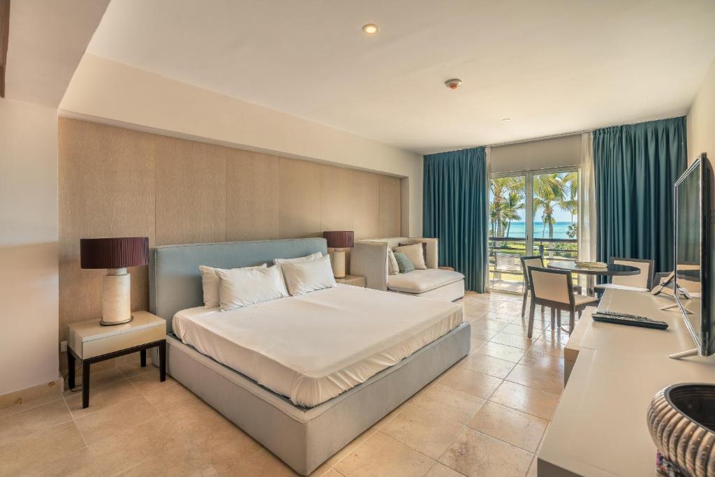 a bedroom with a bed and a desk and a table at NEW 2BR Apt w Jacuzzi Punta Palmera CBA in Punta Cana