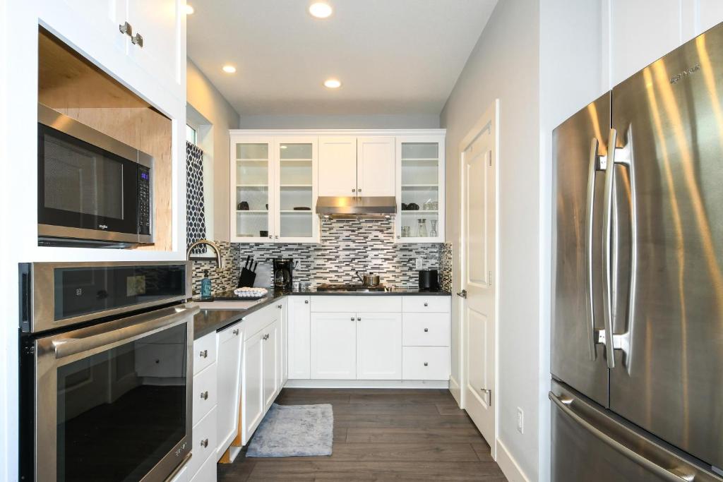a kitchen with white cabinets and a stainless steel refrigerator at 'couve Guesthouse Suite Close To Pdx in Vancouver