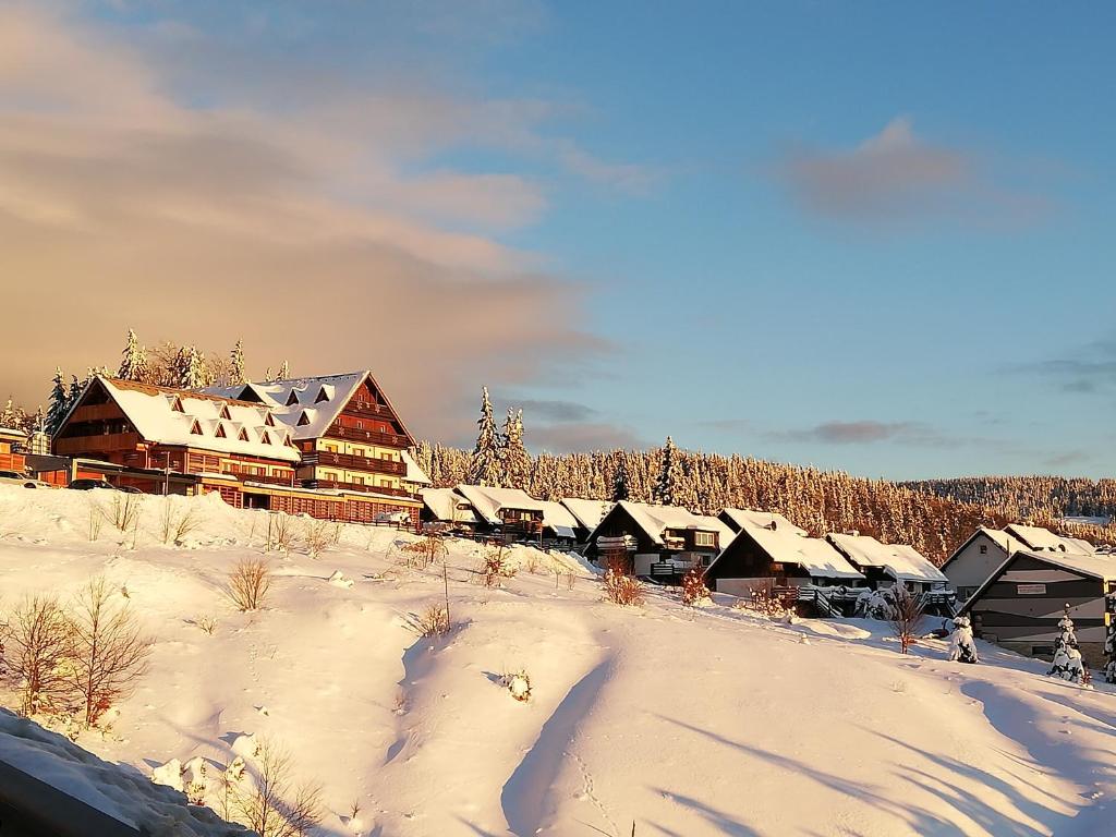 a group of buildings in a snow covered village at Apartma Natura Kope in Šmartno pri Slovenj Gradcu