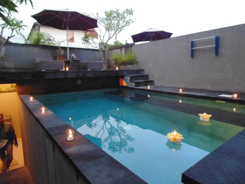 a swimming pool with candles in the water at Bali Elephants Boutique Villa in Jimbaran