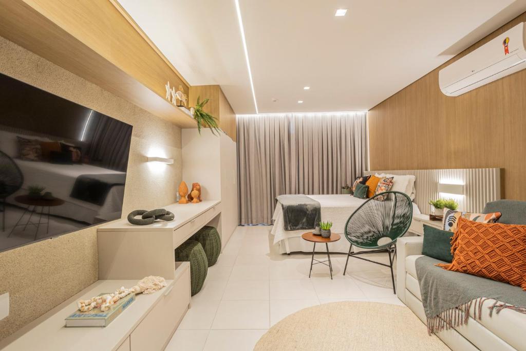 Habitación de hotel con cama y sala de estar. en FLAT 210 - ECORESORT PRAIA DOS CARNEIROS en Tamandaré