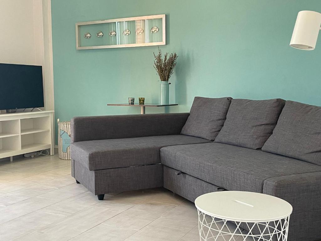 a living room with a gray couch and a table at Lara's Apartment in Lido di Camaiore