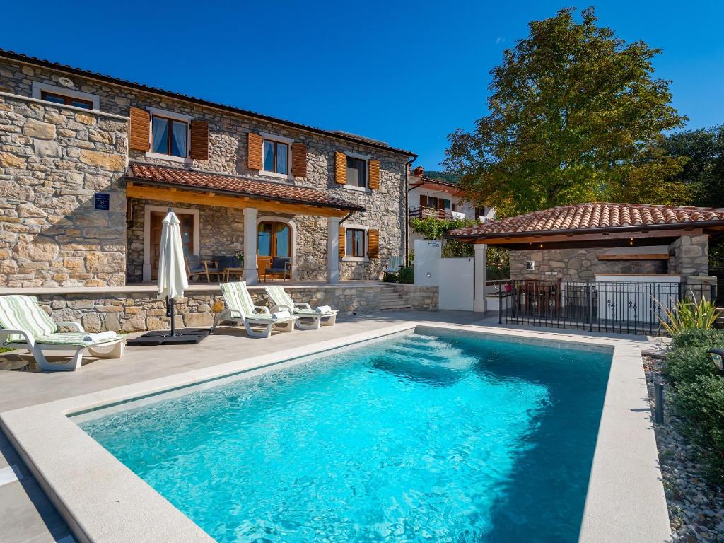 a swimming pool in front of a house at VillaNuova in Šušnjevica