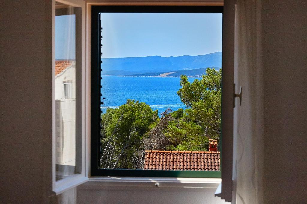 una ventana en una habitación con vistas al océano en Guest House Marija, en Bol