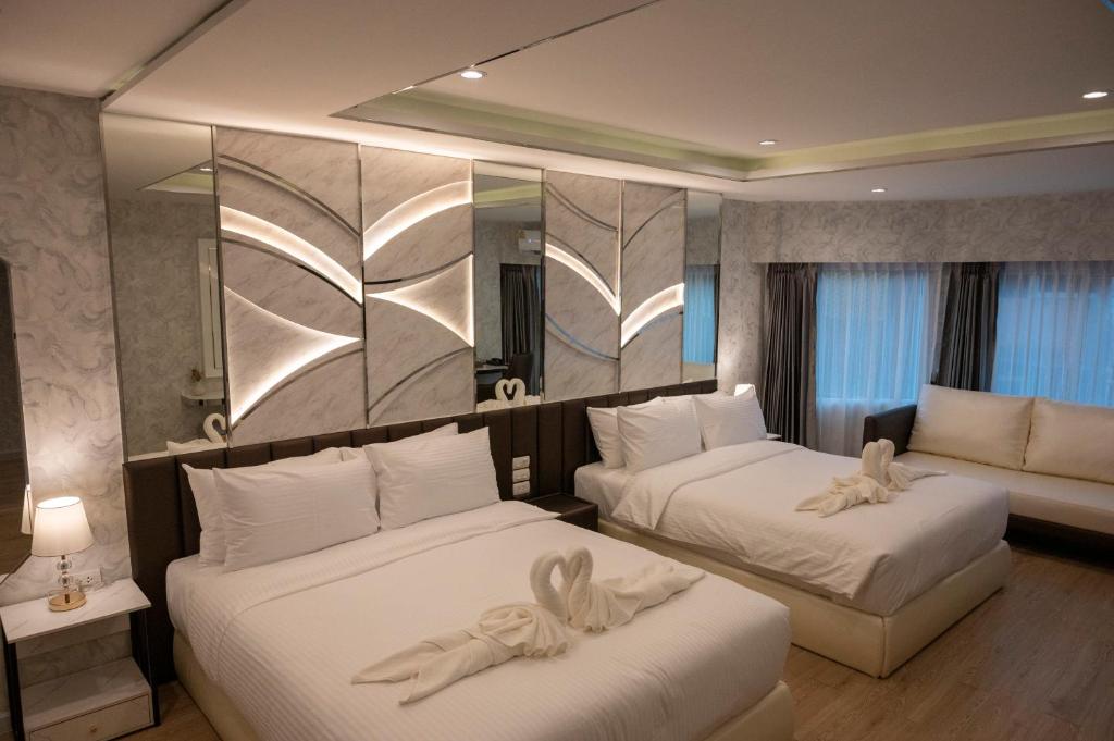 a hotel room with two beds and a couch at Masa Hotel فندق الماسة شارع العرب in Bangkok