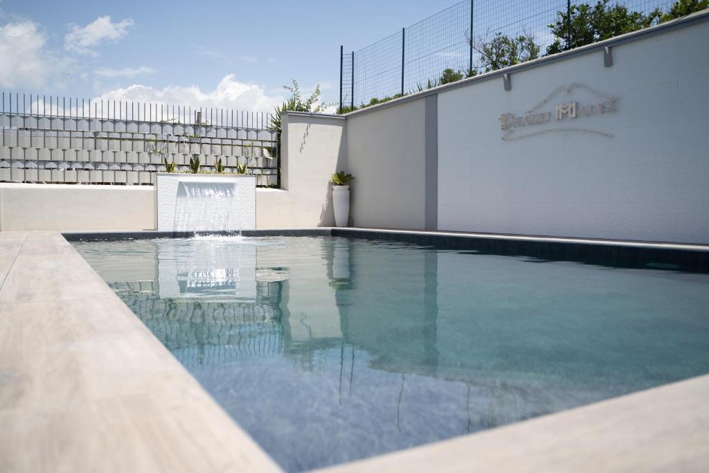 a swimming pool in front of a white fence at Palazzo Marage in Torre del Greco