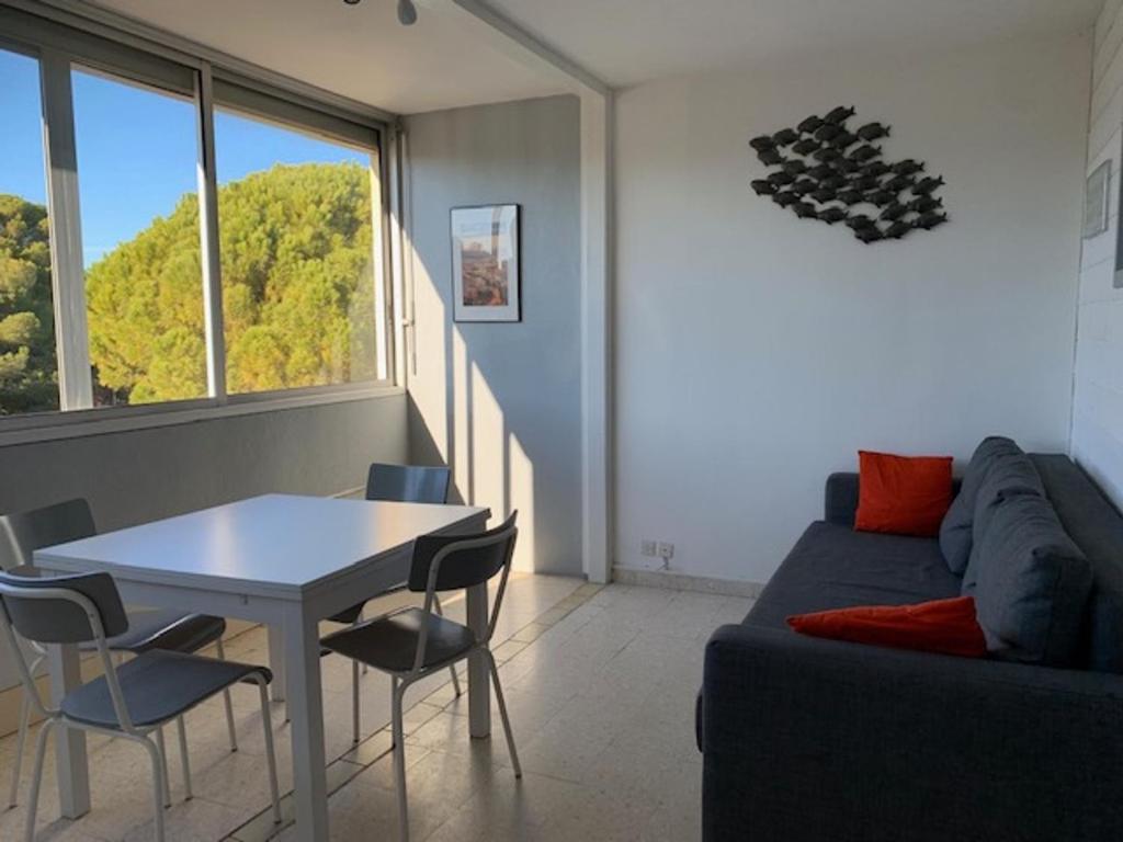 un salon avec une table et un canapé dans l'établissement Appartement 2 étoiles à 5 min des thermes avec parking et clim, animaux acceptés - FR-1-503-129, à Balaruc-les-Bains