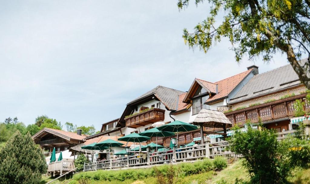 un edificio con sombrillas verdes delante en Eidenberger Alm, en Eidenberg