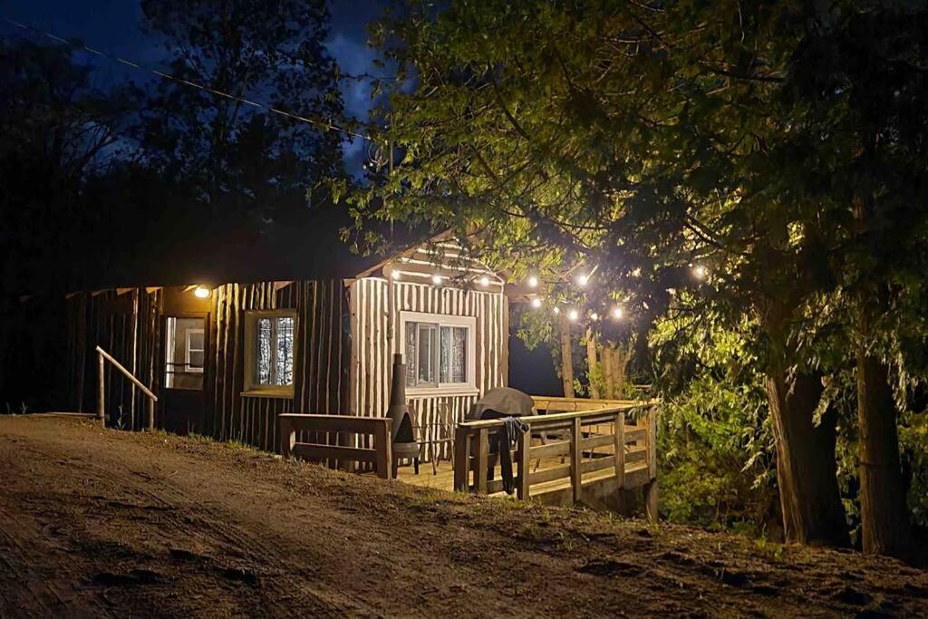 een houten hut met een bank ervoor bij Cedar Cabin - North Frontenac Lodge in Ompah