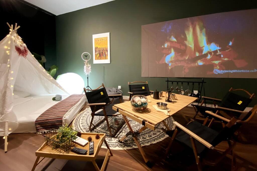 Zimmer mit einem Bett, Tischen und Stühlen in der Unterkunft Urban Campfire Parc3 by Offweek in Kuala Lumpur