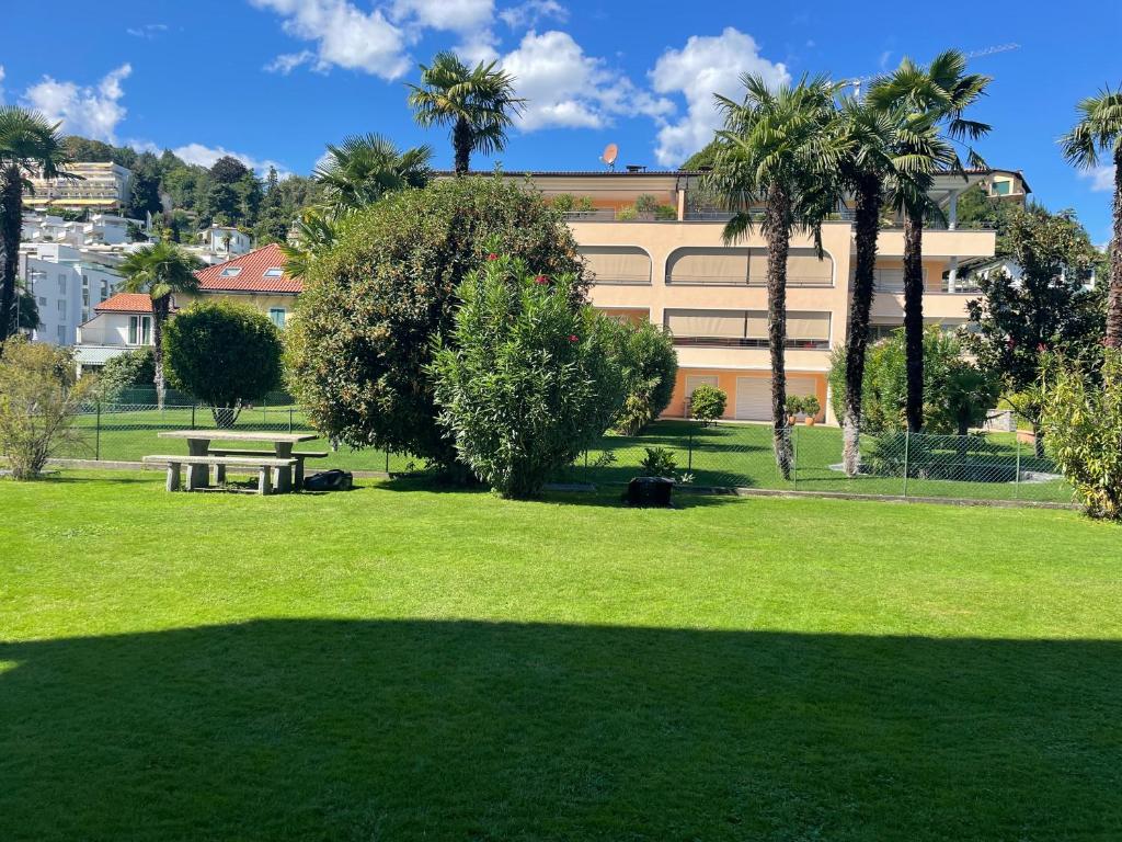 un parque con mesa de picnic, árboles y un edificio en Ascona: San Materno-Mary en Ascona