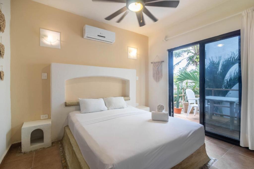 um quarto com uma cama e uma grande janela em Hotel Boutique Pachamama em Mahahual