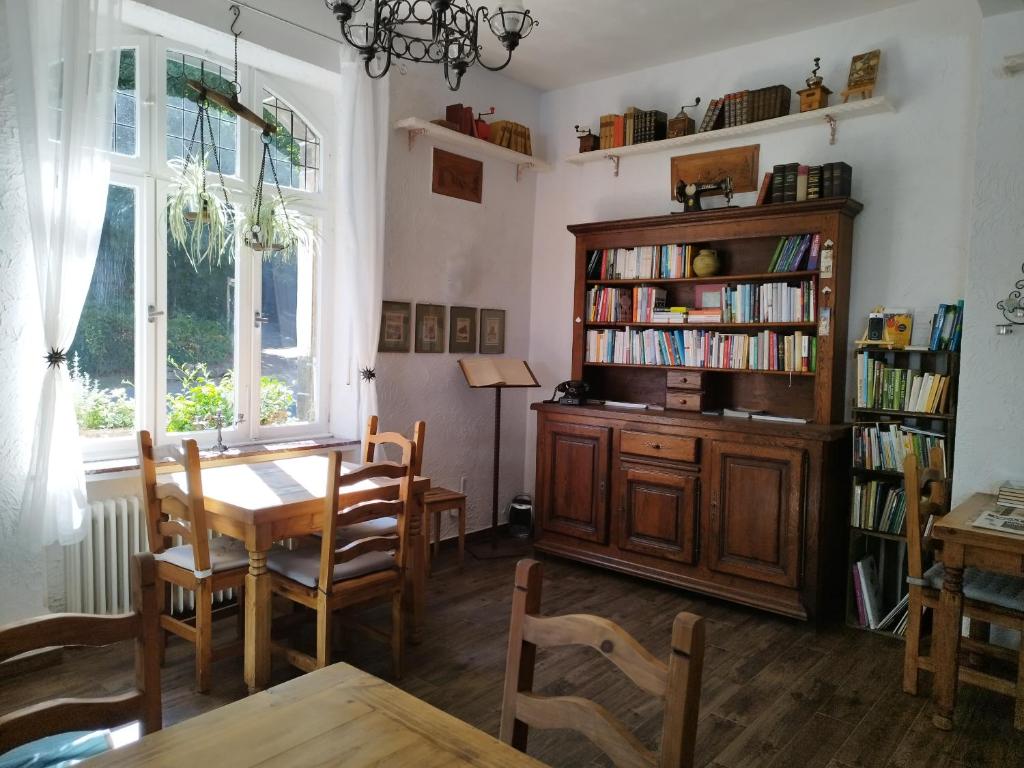 uma sala de jantar com uma mesa e uma estante de livros em Schmökermühle em Andernach