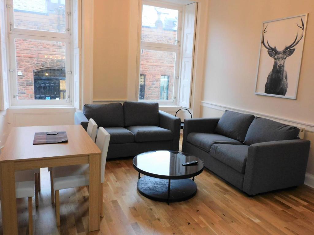 a living room with two couches and a table at Beautiful 3 bed apt in the City Centre in Glasgow