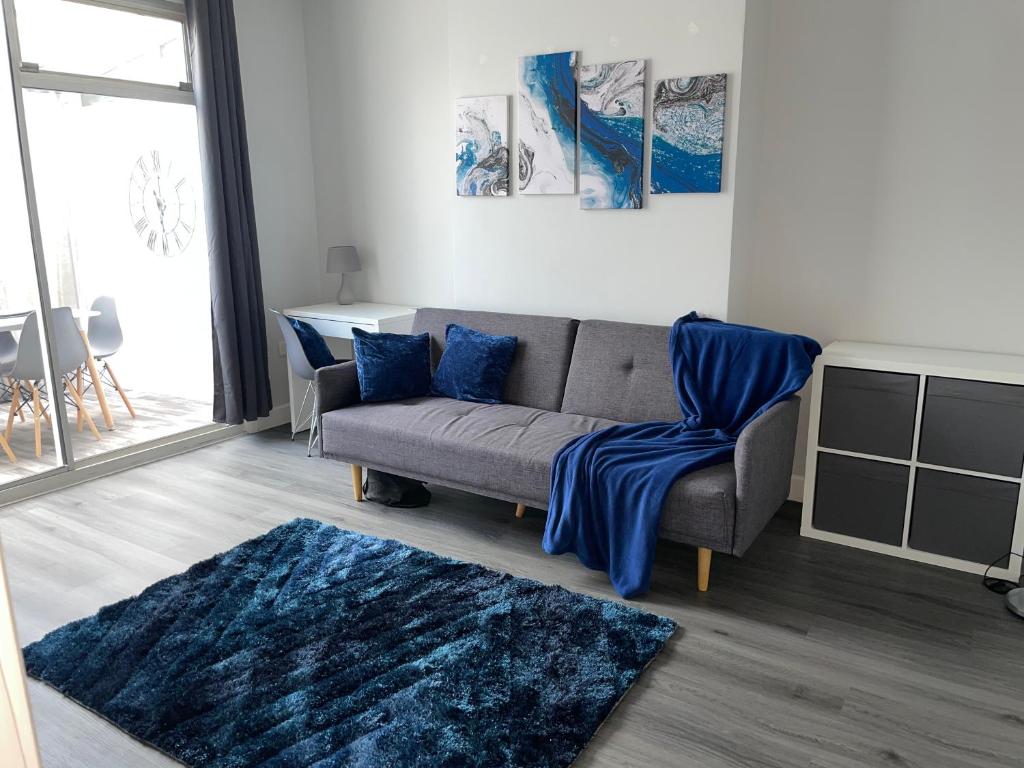 - un salon avec un canapé et un tapis bleu dans l'établissement Modern 4 Bedroom House 10 mins from East Croydon with Garden and Free parking, à South Norwood