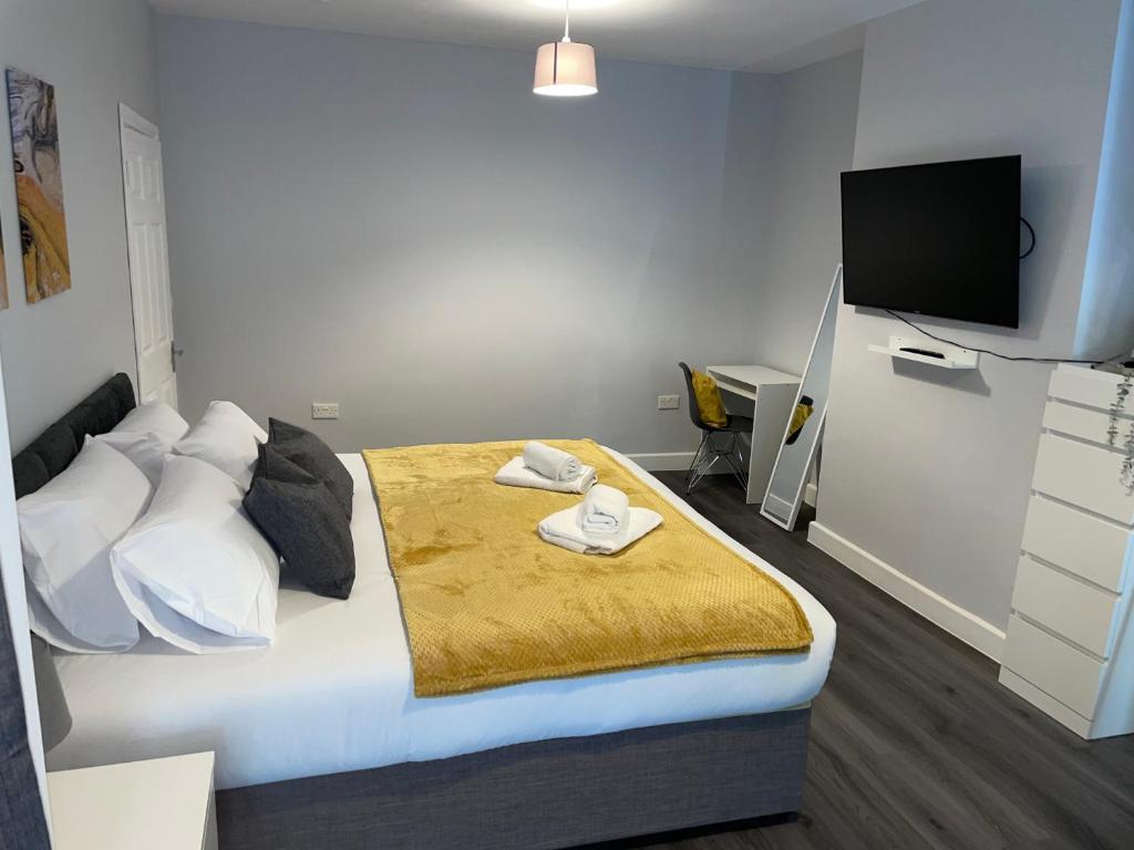 South NorwoodにあるModern 4 Bedroom House 10 mins from East Croydon with Garden and Free parkingのベッドルーム1室(黄色い毛布付きのベッド1台付)