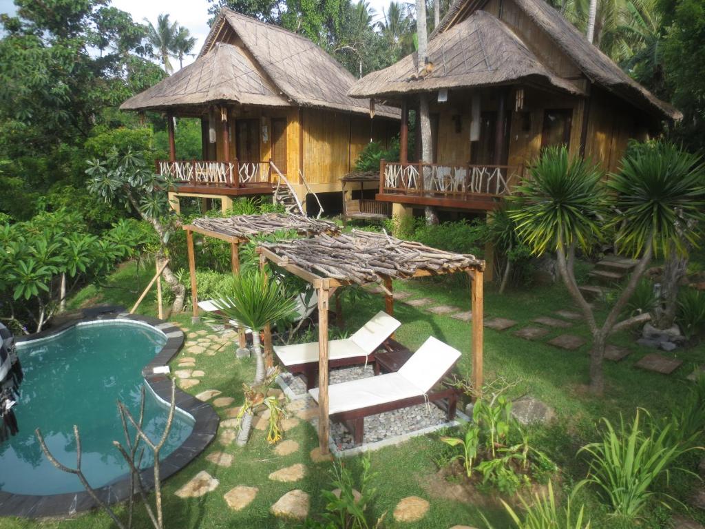 a resort with a pool and a house at Jepun Didulu Cottages in Candidasa