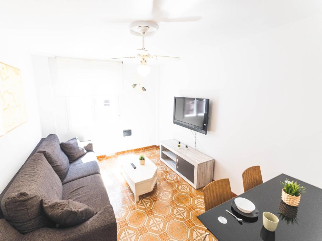 uma sala de estar com um sofá e uma mesa em Apartamento cerra playa em Gijón