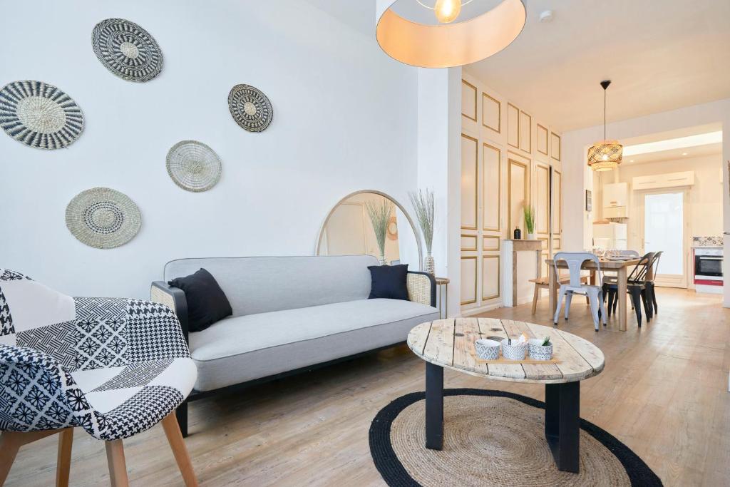 uma sala de estar com um sofá e uma mesa em Locations Tourcoing - Le Renaix em Tourcoing