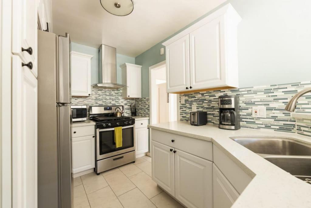 eine Küche mit weißen Schränken und einem Waschbecken in der Unterkunft Inviting Home in Historic Leimert Park in Los Angeles