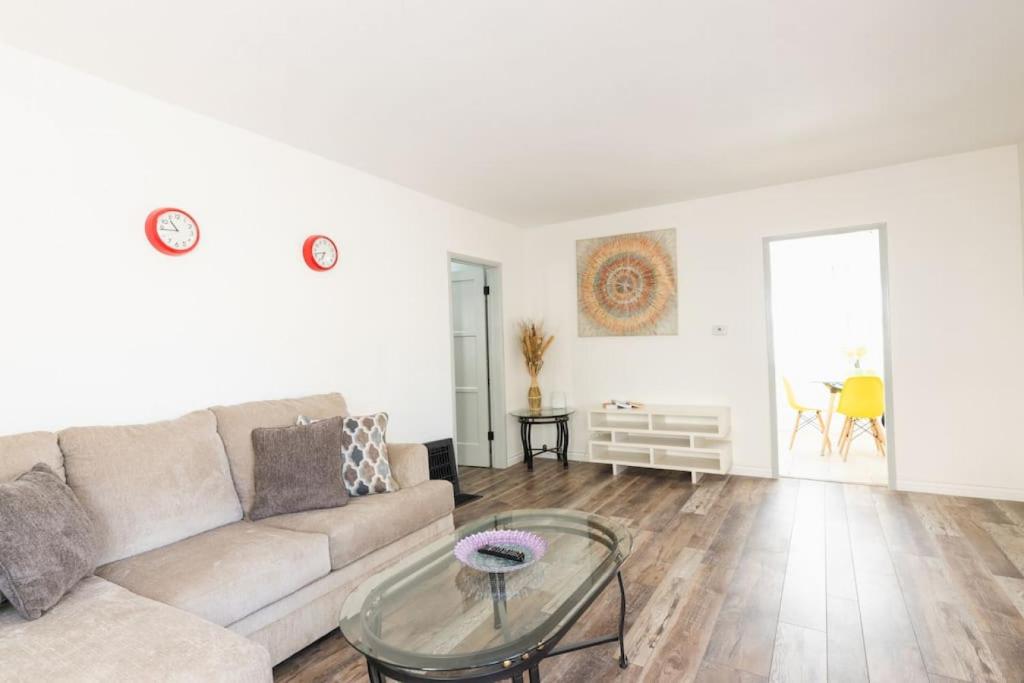 a living room with a couch and a glass table at Spring Charmer In The Heart Of The City in Los Angeles