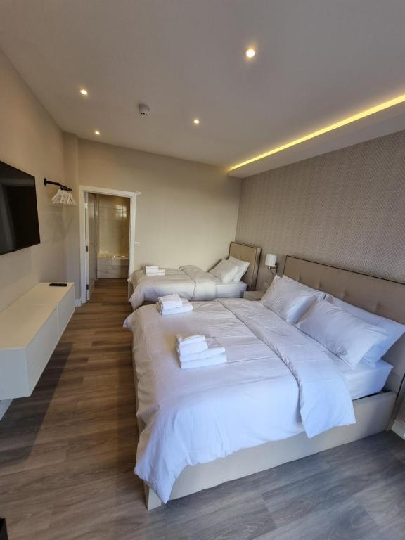 a hotel room with three beds and a flat screen tv at Hotel CG London in London