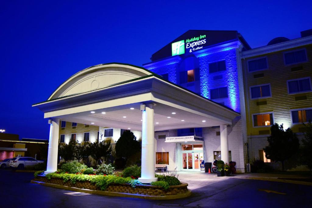 Holiday Inn Express Hotel & Suites Watertown - Thousand Islands, an IHG Hotel في ووترتاون: فندق مع شرفة امام مبنى