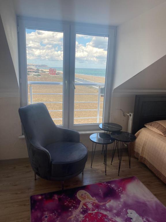 a bedroom with a chair and a view of the ocean at İstanbul havaalanına10 dk olan oda in Arnavutköy