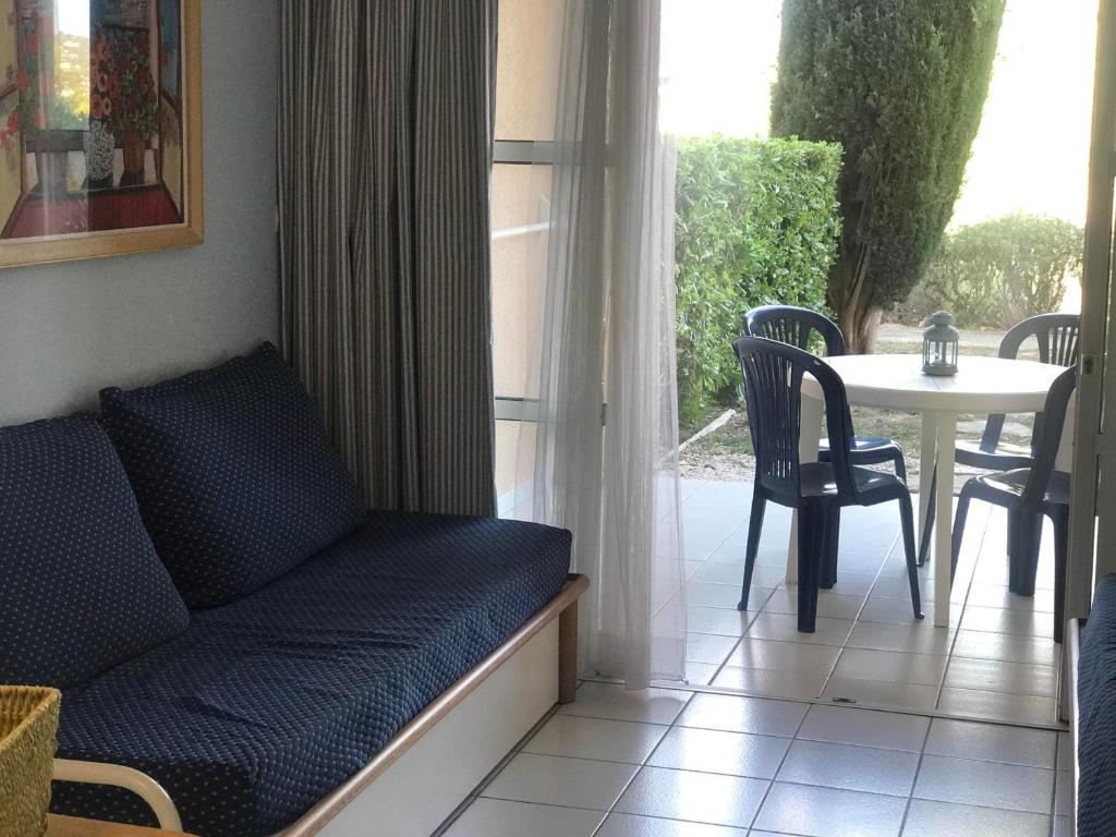 un salon avec un canapé, une table et une fenêtre dans l'établissement Studio 4 pers, terrasse couverte, piscine et parking, Cap Esterel - FR-1-504-653, à Saint-Raphaël