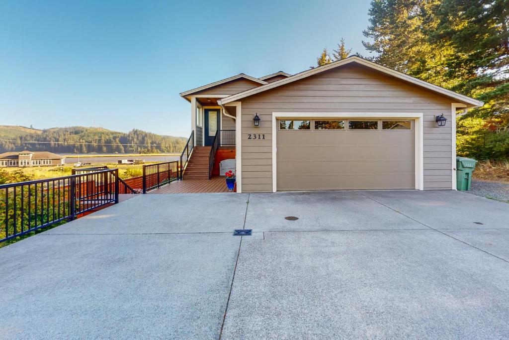 a house with a garage with a driveway at Siuslaw Tides 2 in Florence
