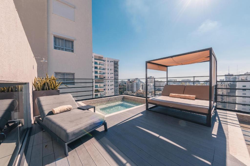 einen Balkon mit einem Bett und einem Pool auf einem Gebäude in der Unterkunft Fully Serviced Apartment at Regatta Living - 3A in Santo Domingo