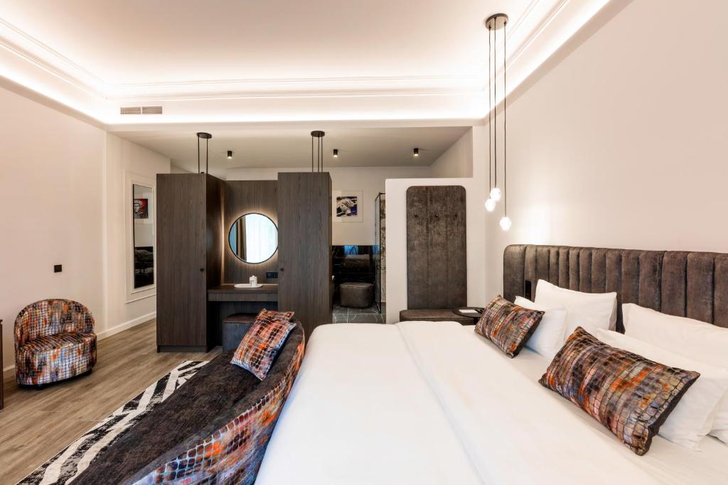 a bedroom with a large white bed and a mirror at O11 Boutique Hotel Vienna in Vienna