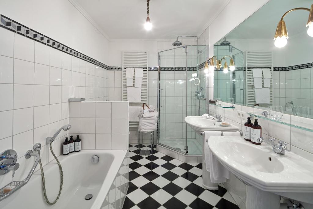 a bathroom with two sinks and a tub and a shower at Kristiania Lech in Lech am Arlberg