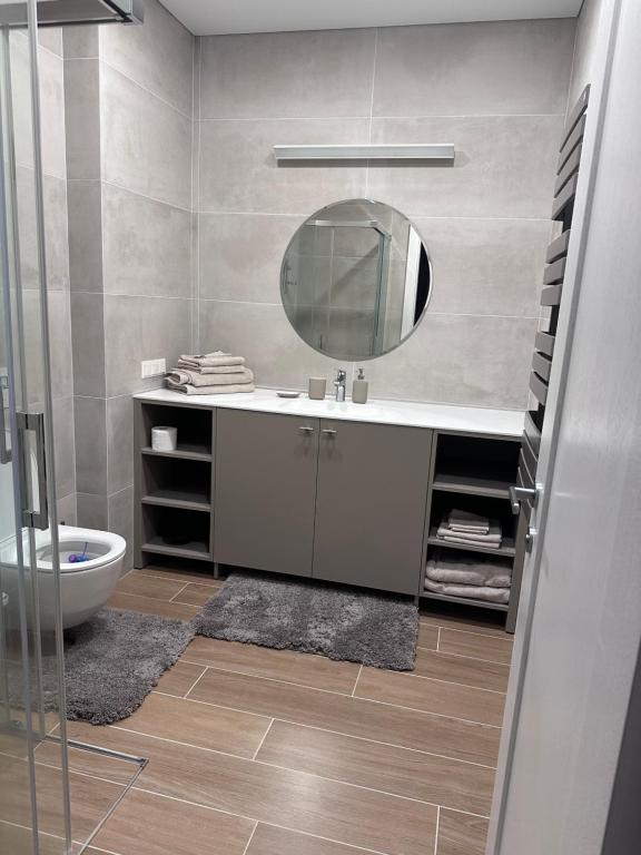 a bathroom with a sink and a mirror at Naujai įrengti pušyno apartamentai - bekontaktis įėjimas in Birštonas