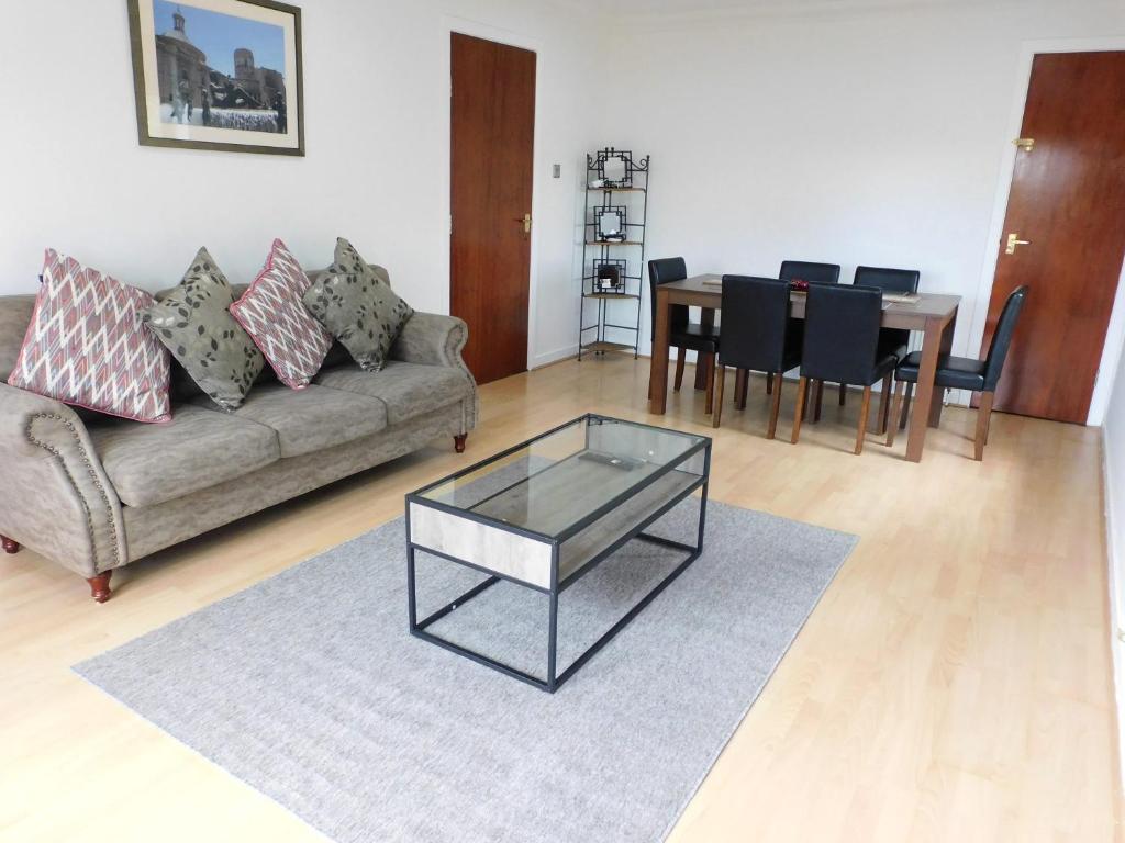 a living room with a couch and a table at Charming 2 bed apt close to City and SEC Hydro in Glasgow